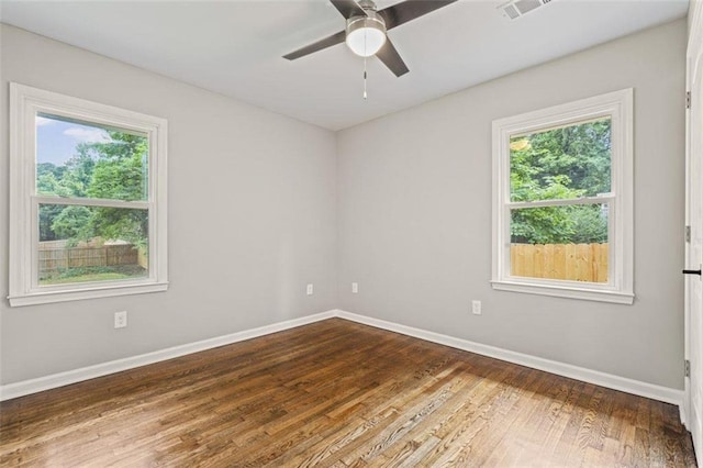 spare room with hardwood / wood-style flooring, a healthy amount of sunlight, and ceiling fan