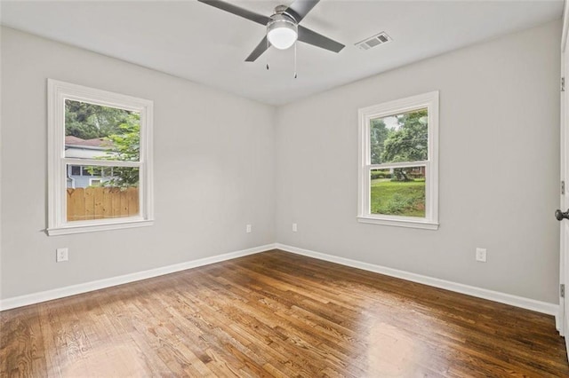 unfurnished room with ceiling fan, a wealth of natural light, and hardwood / wood-style floors