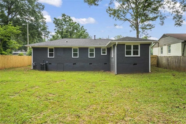 rear view of house with a yard and central AC unit