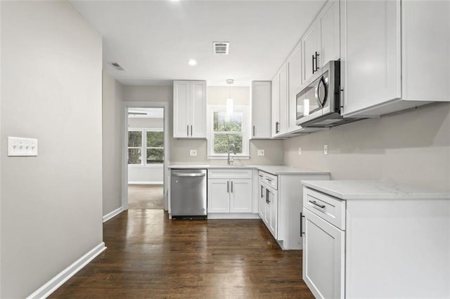 kitchen featuring hanging light fixtures, sink, white cabinets, appliances with stainless steel finishes, and dark hardwood / wood-style flooring