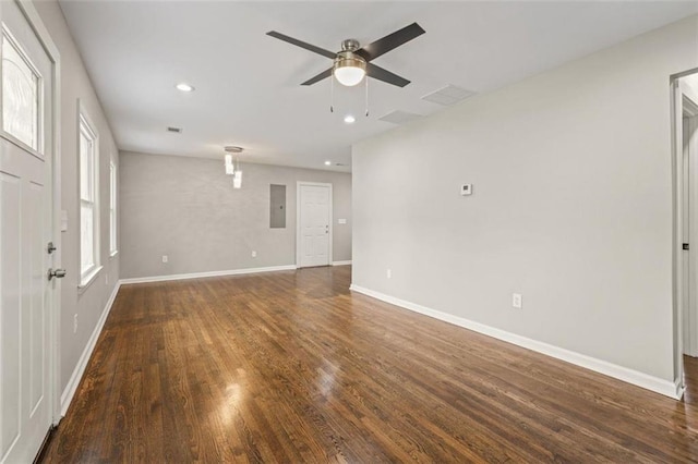 empty room featuring dark wood-type flooring, ceiling fan, a healthy amount of sunlight, and electric panel