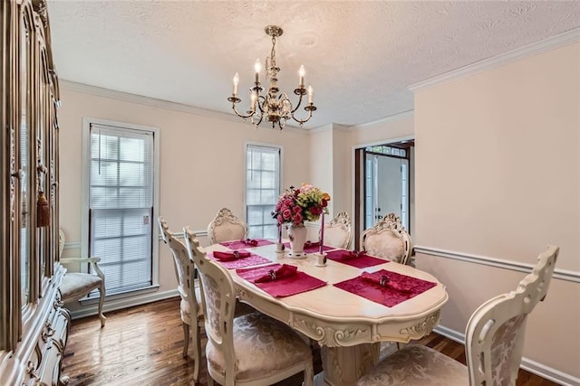 dining room featuring a notable chandelier, ornamental molding, wood finished floors, and a textured ceiling