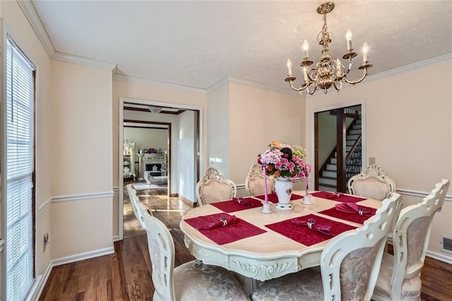 dining space featuring ornamental molding, an inviting chandelier, and wood finished floors