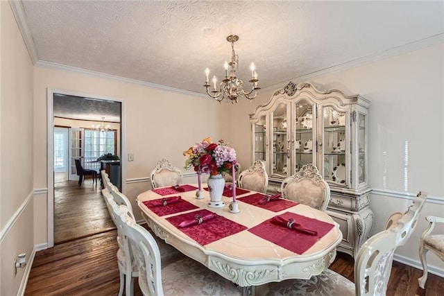 dining space with dark wood finished floors, a textured ceiling, and an inviting chandelier