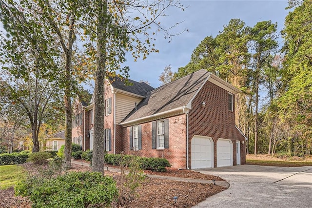 view of side of home with concrete driveway, a garage, and brick siding