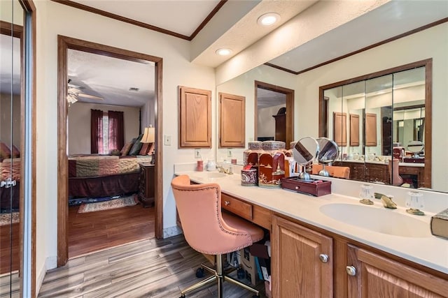 ensuite bathroom featuring vanity, wood finished floors, a ceiling fan, ensuite bath, and crown molding