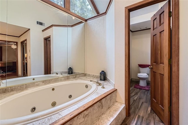 bathroom with visible vents, a jetted tub, and toilet