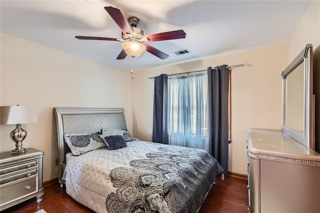 bedroom with baseboards, visible vents, dark wood-style flooring, and ceiling fan