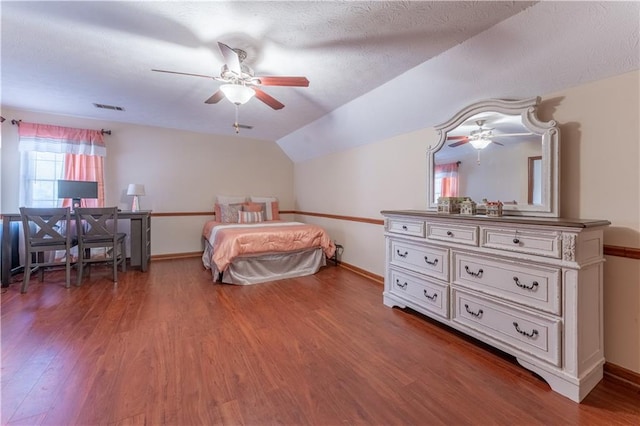 bedroom featuring visible vents, lofted ceiling, baseboards, and wood finished floors