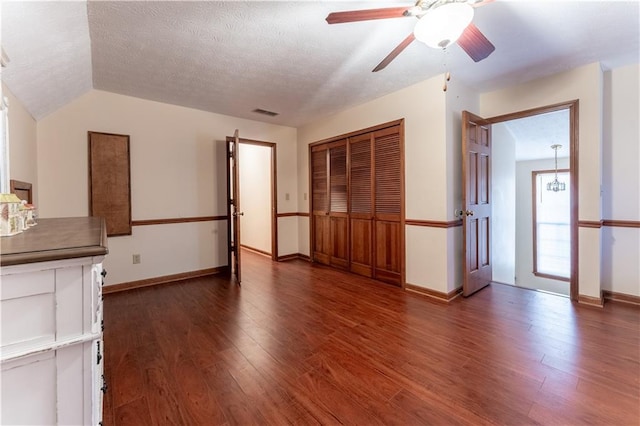 unfurnished living room featuring a textured ceiling, baseboards, and wood finished floors