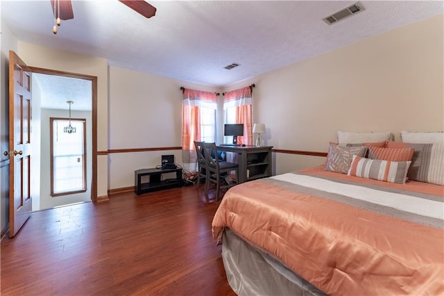 bedroom featuring visible vents, a textured ceiling, and wood finished floors