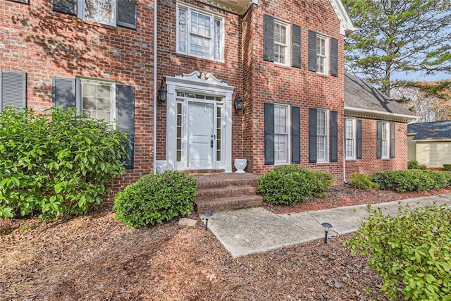 entrance to property featuring brick siding