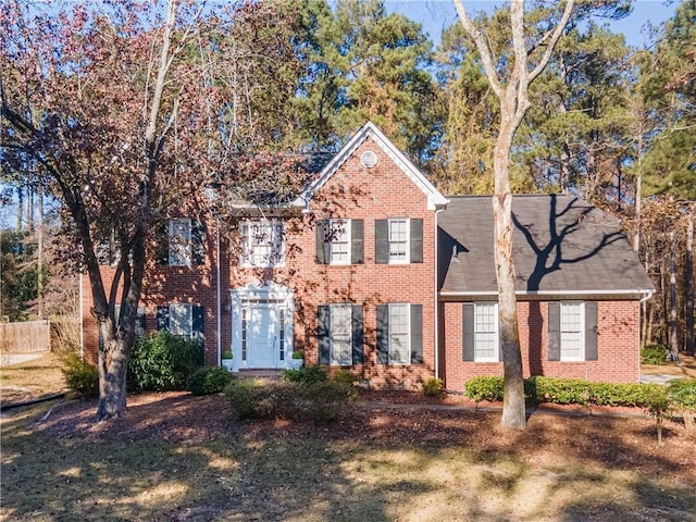 colonial inspired home featuring brick siding