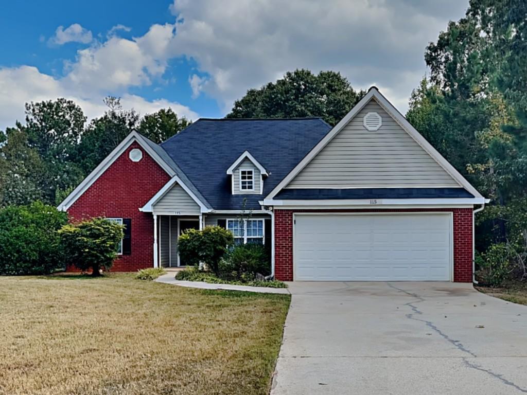 115 Hugh Dr, Covington, GA 30016 - view of front of home featuring brick siding, a garage, a front lawn, and driveway