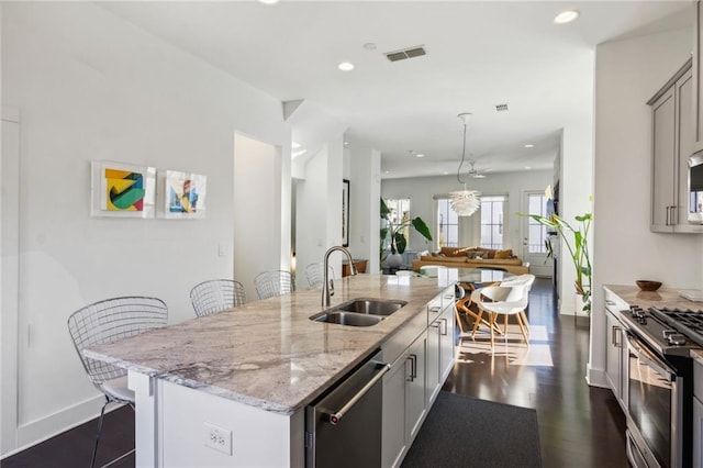 2034 Rockledge Rd NE, Atlanta, GA 30324 - kitchen featuring a sink, appliances with stainless steel finishes, recessed lighting, a kitchen island with sink, and a kitchen breakfast bar