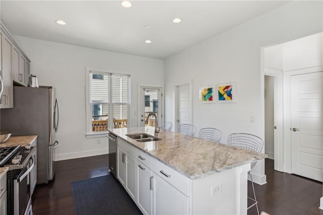 2034 Rockledge Rd NE, Atlanta, GA 30324 - kitchen with a sink, appliances with stainless steel finishes, a kitchen breakfast bar, baseboards, and dark wood finished floors