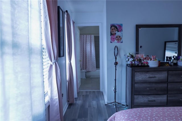 bedroom featuring ensuite bathroom and hardwood / wood-style floors