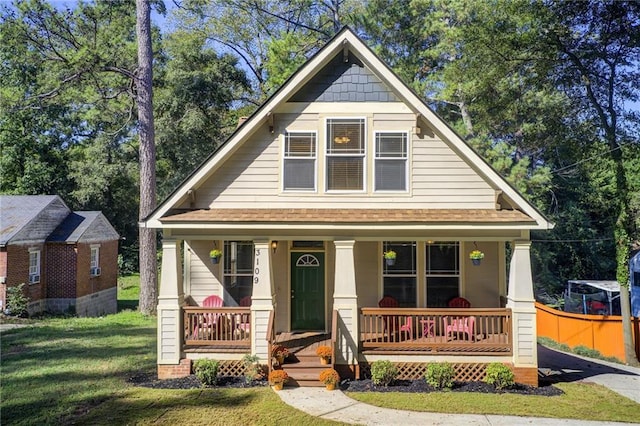 bungalow-style house featuring covered porch and a front yard