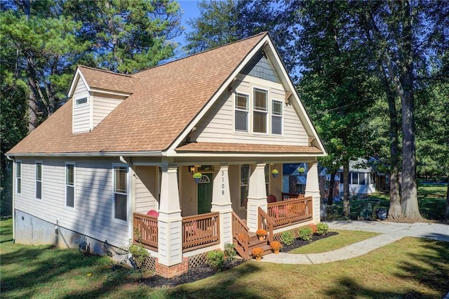 craftsman-style house featuring covered porch and a front yard