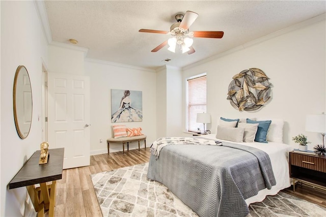 bedroom with hardwood / wood-style floors, a textured ceiling, ceiling fan, and crown molding