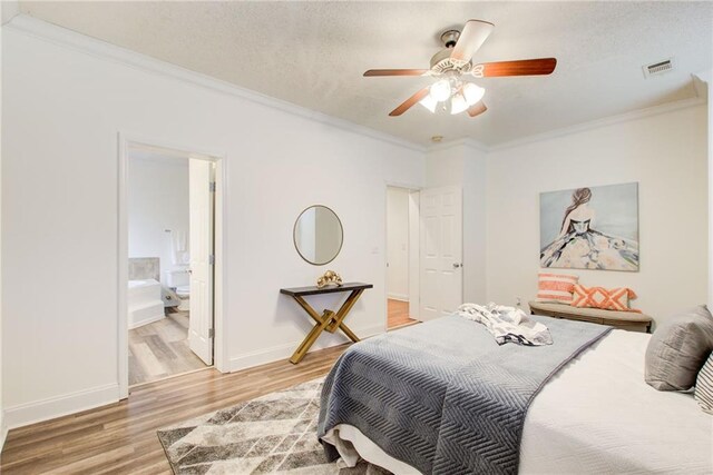 bedroom featuring ensuite bath, ceiling fan, crown molding, a textured ceiling, and hardwood / wood-style flooring