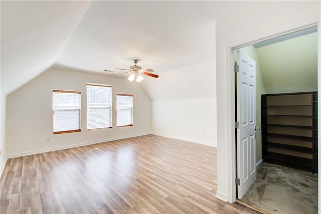 additional living space with ceiling fan, light hardwood / wood-style floors, and vaulted ceiling