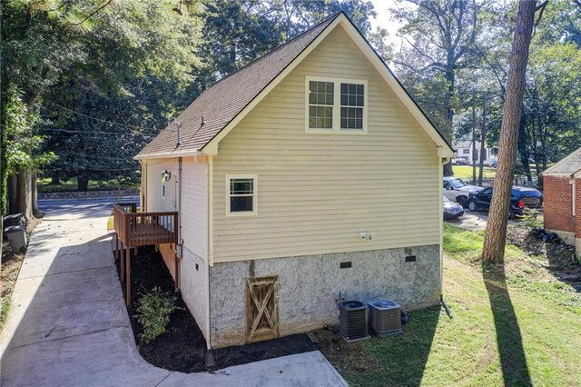 view of side of home featuring central air condition unit and a yard