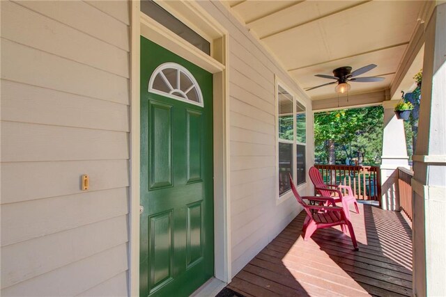 view of exterior entry with ceiling fan and a porch