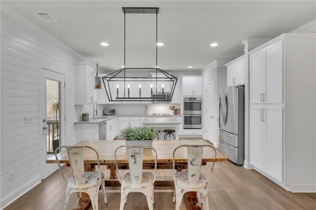 kitchen featuring white cabinetry, light countertops, light wood-type flooring, and appliances with stainless steel finishes