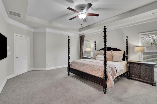 carpeted bedroom with a tray ceiling, ceiling fan, baseboards, and visible vents