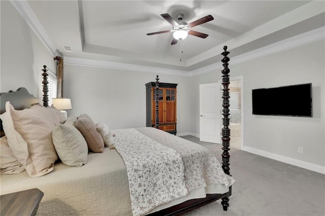 carpeted bedroom featuring a ceiling fan, a tray ceiling, baseboards, and crown molding