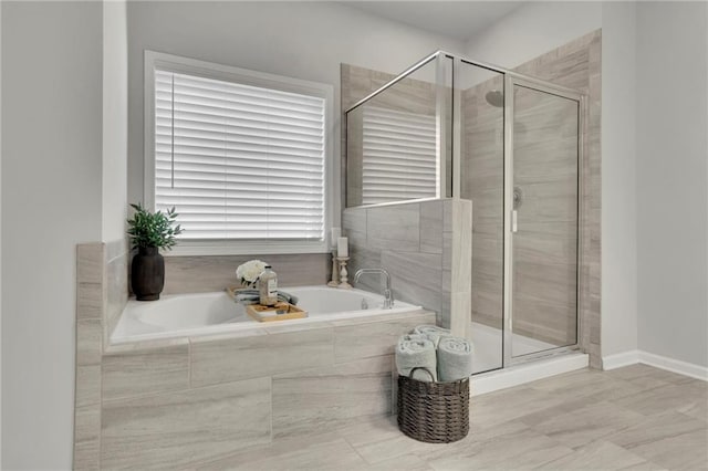 bathroom with a stall shower and a garden tub
