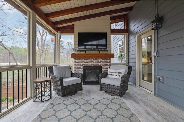 sunroom with beamed ceiling and an outdoor brick fireplace