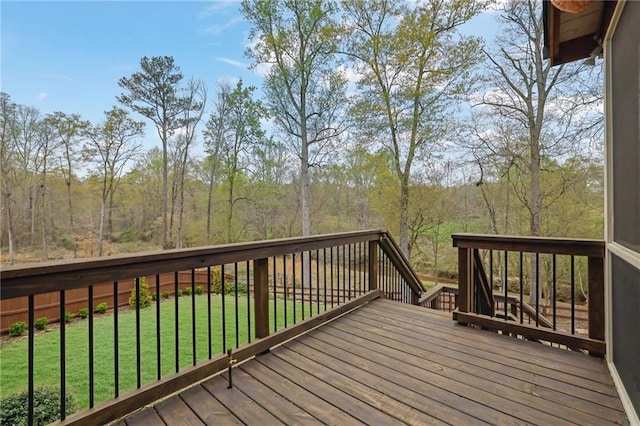wooden terrace featuring a yard and a wooded view