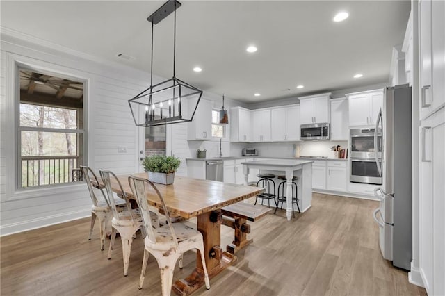 dining space featuring light wood finished floors, a notable chandelier, visible vents, and recessed lighting