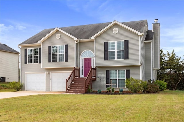 bi-level home featuring a front lawn, central AC, and a garage