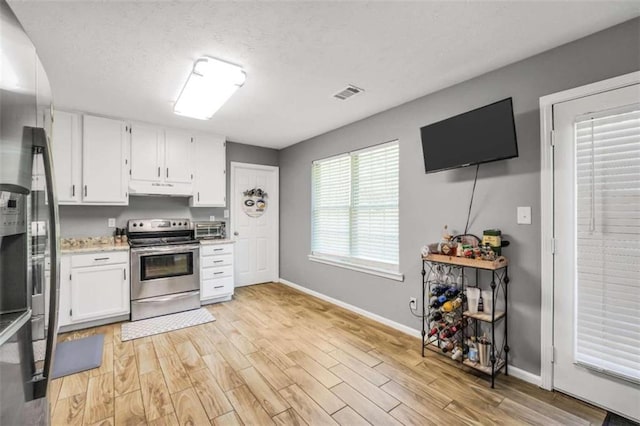 kitchen featuring visible vents, stainless steel appliances, light wood-type flooring, under cabinet range hood, and white cabinetry