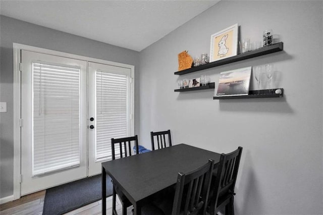 dining area with french doors and wood finished floors