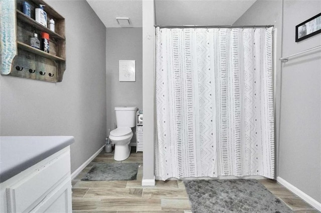 full bath with vanity, wood finished floors, toilet, and baseboards