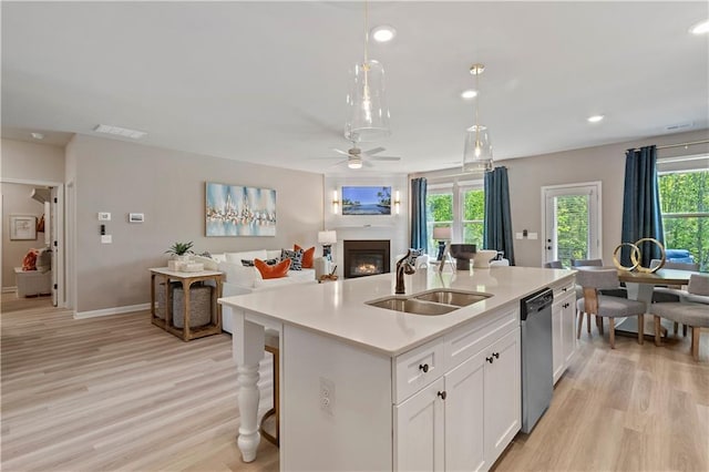 kitchen with sink, decorative light fixtures, dishwasher, a kitchen island with sink, and white cabinets