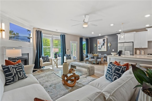 living room with light hardwood / wood-style flooring and ceiling fan