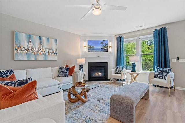 living room featuring wood-type flooring and ceiling fan