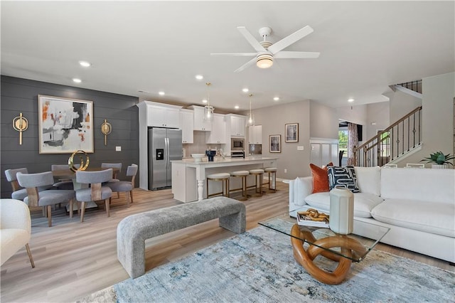 living room featuring ceiling fan and light hardwood / wood-style floors