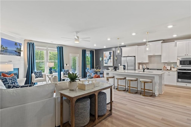 living room with ceiling fan and light hardwood / wood-style floors