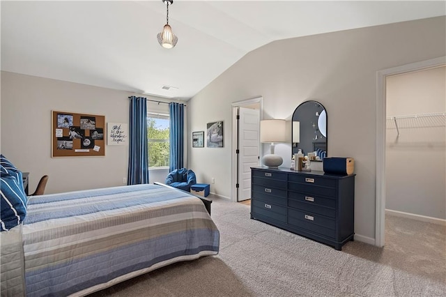 carpeted bedroom featuring lofted ceiling, a walk in closet, and a closet