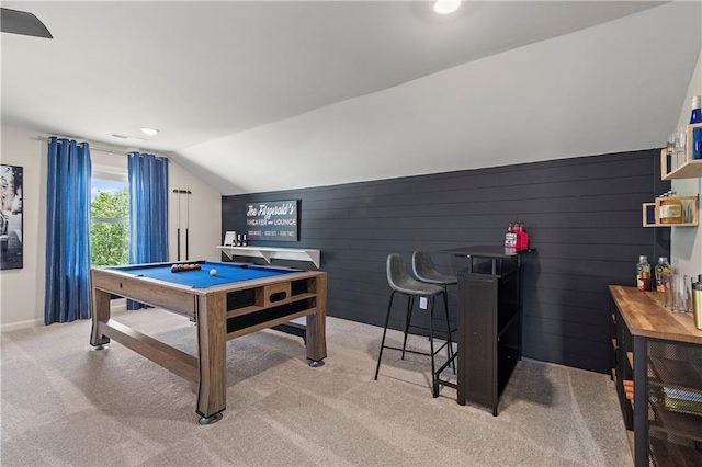 game room with pool table, wooden walls, vaulted ceiling, and light carpet