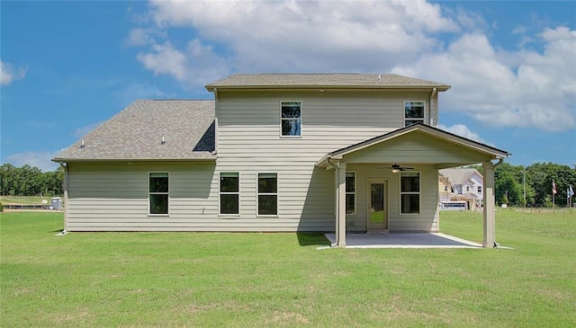 rear view of property featuring ceiling fan, a yard, and a patio