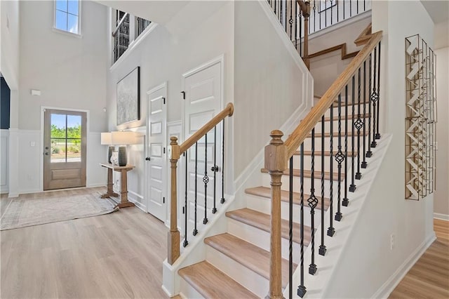 entrance foyer featuring a towering ceiling and light hardwood / wood-style floors