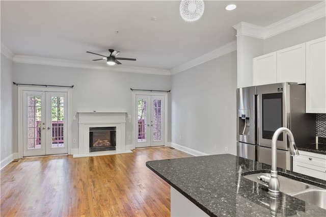 kitchen featuring french doors, stainless steel fridge, a sink, and white cabinets