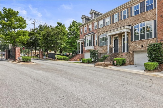 multi unit property with a garage and brick siding